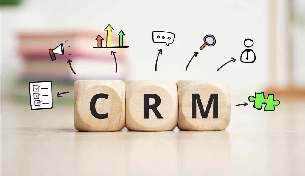 Кубики з літерами CRM та іконками, що символізують базу клієнтів, воронку продажів і аналітику