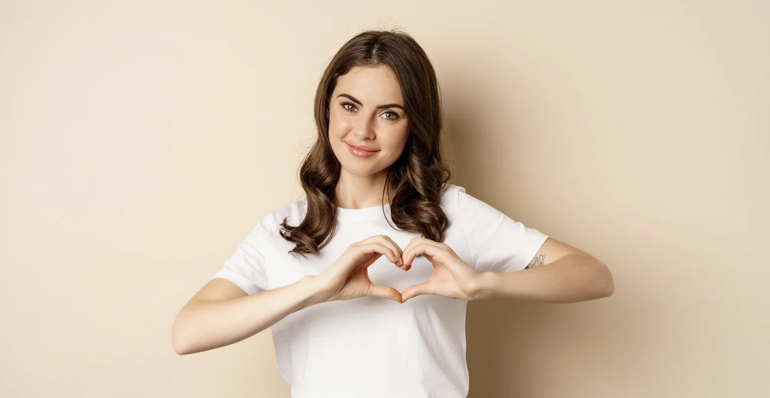 Дівчина показує жест серця як символ високої лояльності клієнтів та довіри до бренду